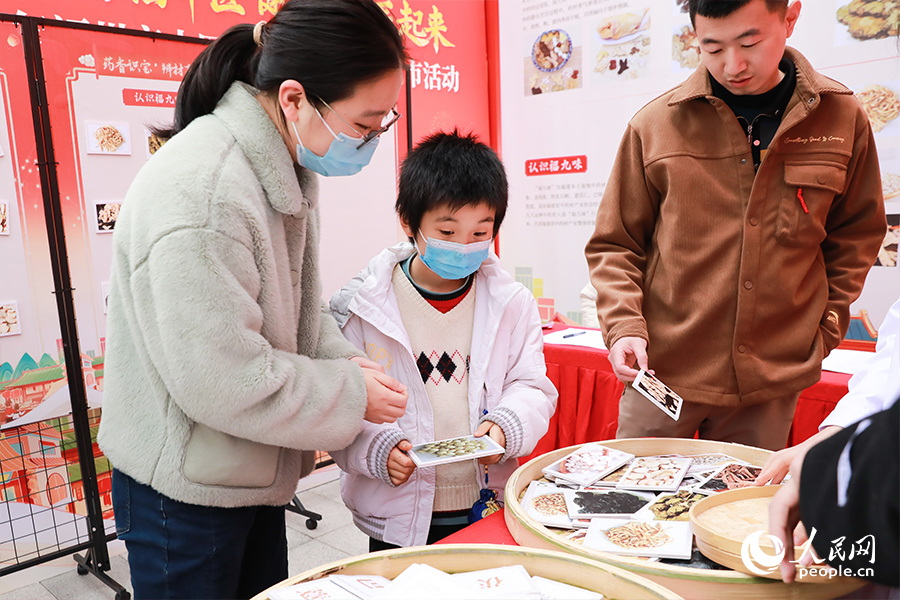 市民辨别“八珍药膳”所需中药材，参与互动。人民网 陈永整摄