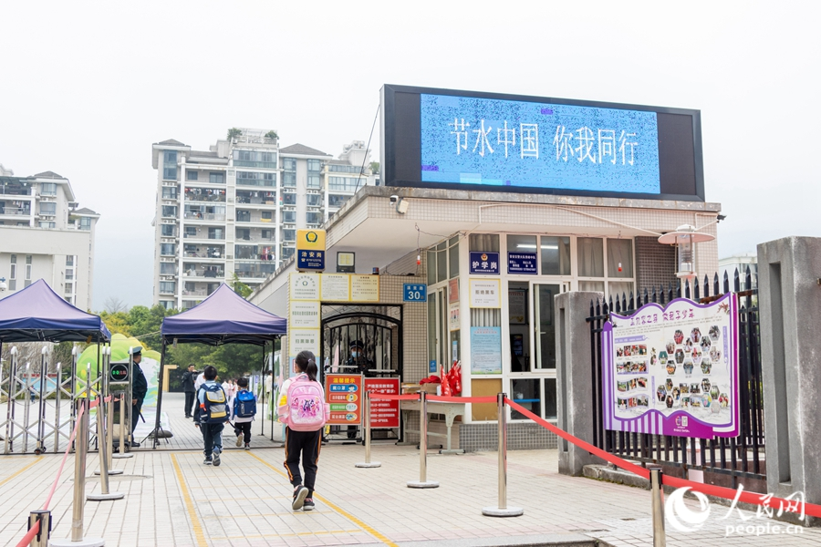 校门口的显示屏上,写着“节水中国,你我同行”的口号。实习生康磊摄