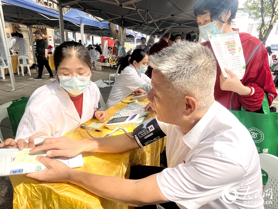 一位市民在展位前测量血压。人民网 钱嘉禾摄