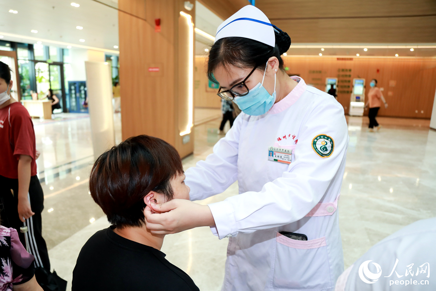 市民体验耳穴压豆中医适宜技术。人民网 陈永整摄