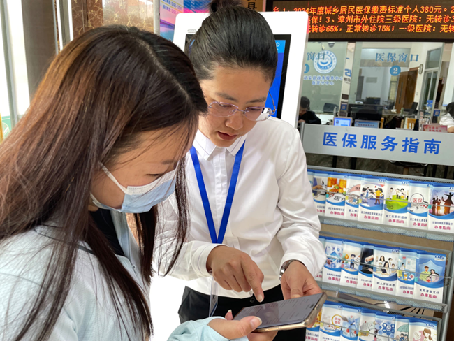 诏安医保局工作人员指导办事群众激活医保电子凭证。