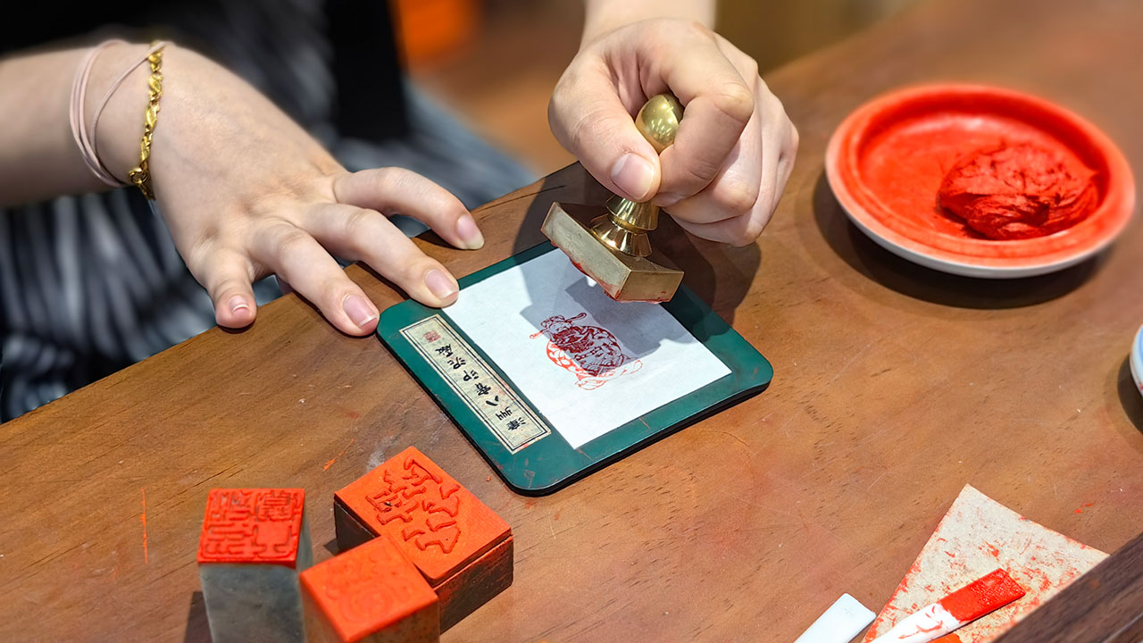 游客在漳州古城体验八宝印泥拓印