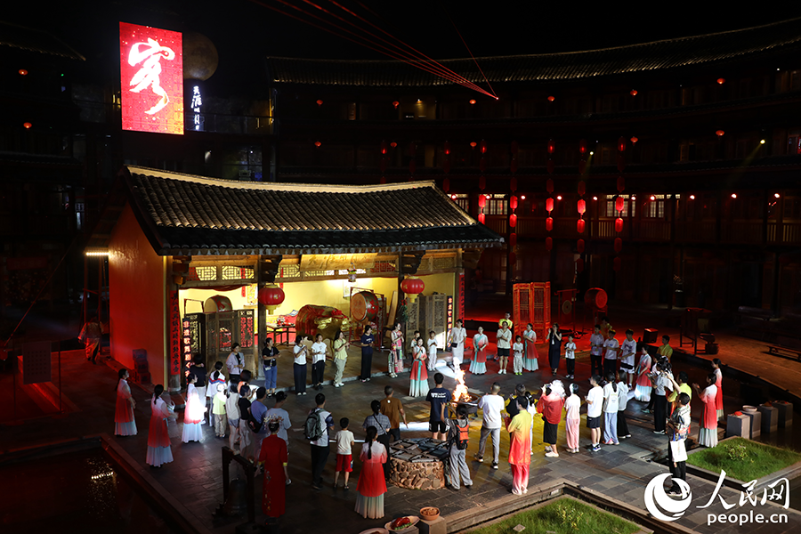 游客登上“土楼舞台”与演员同台互动。人民网 李唯一摄