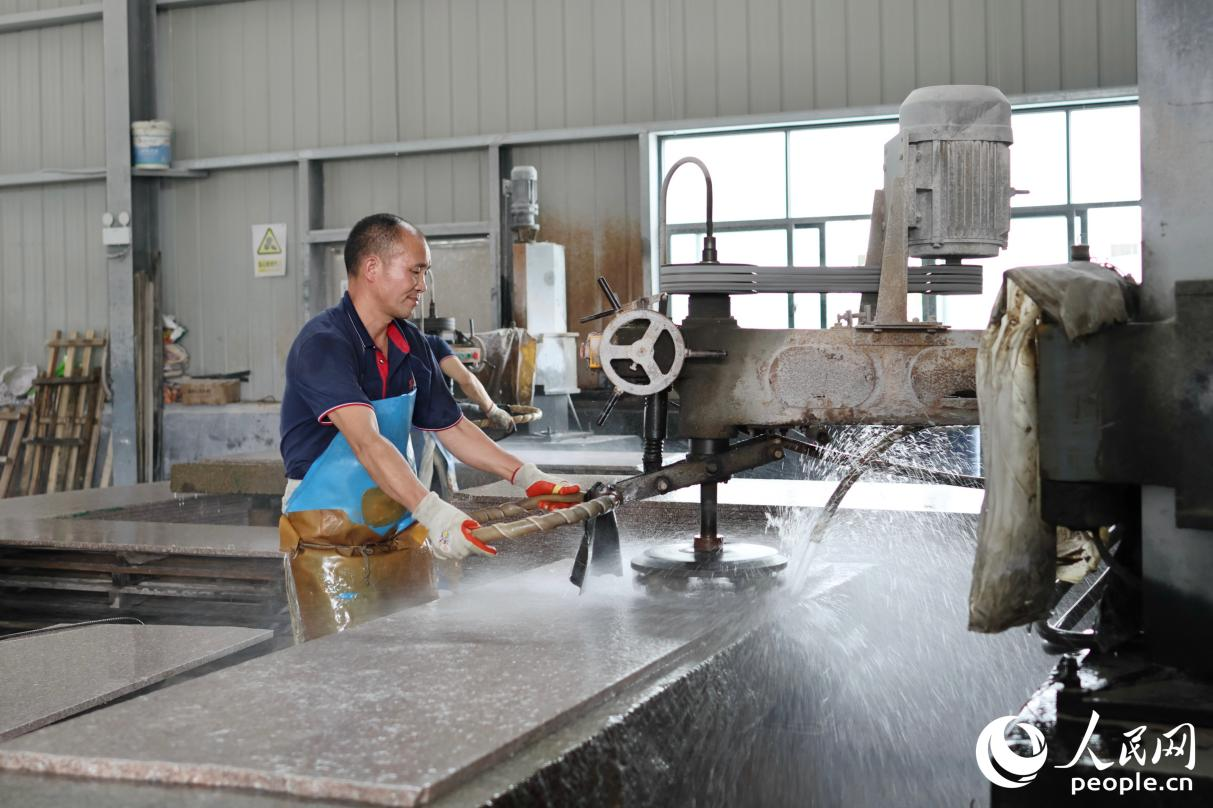 厂房内,员工正在带水作业。人民网 李昌乾摄