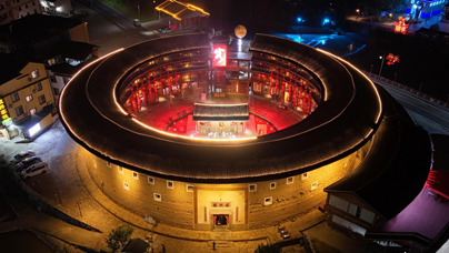 “土楼”变“金楼”
一座座中式美学含量满满的圆形建筑在暮色下巍然屹立，那便是世界文化遗产永定土楼群。屹立百年的土楼在灯光的映照下绚丽夺目，宛若“金楼”。