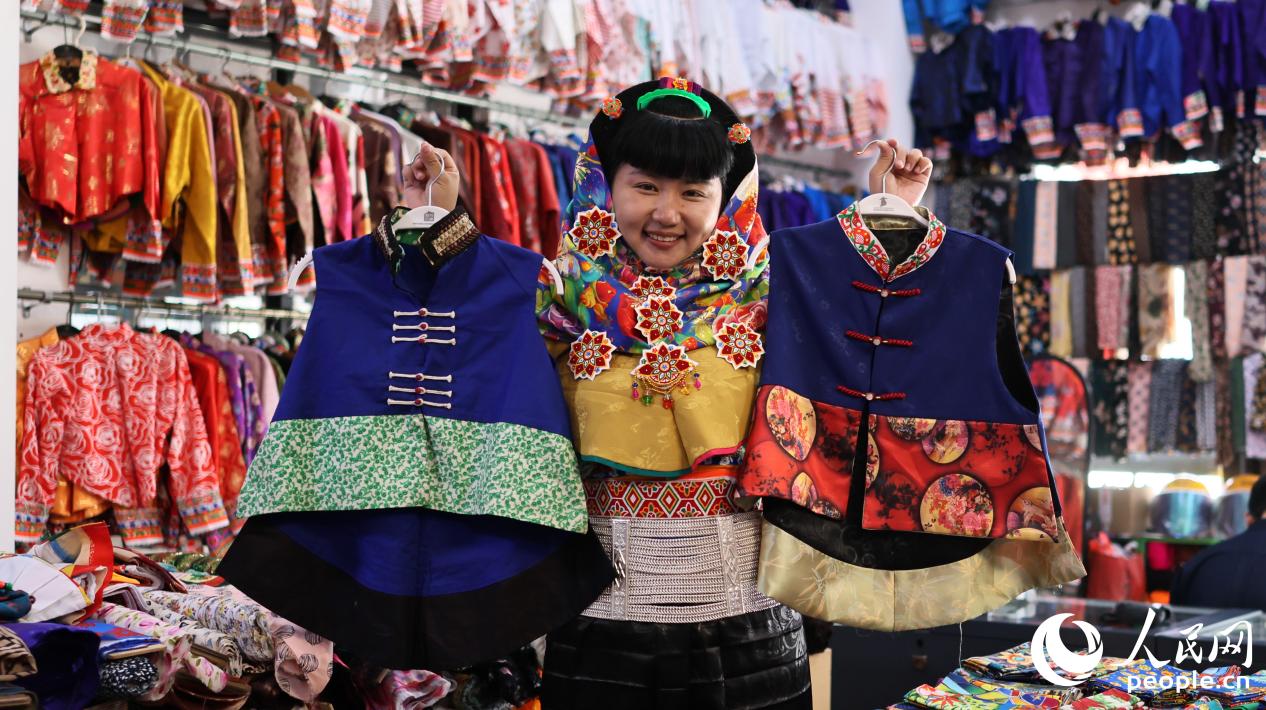 惠安女服饰非物质文化遗产传承人曾茹婷展示改良前后的“贴背”。人民网 李昌乾摄